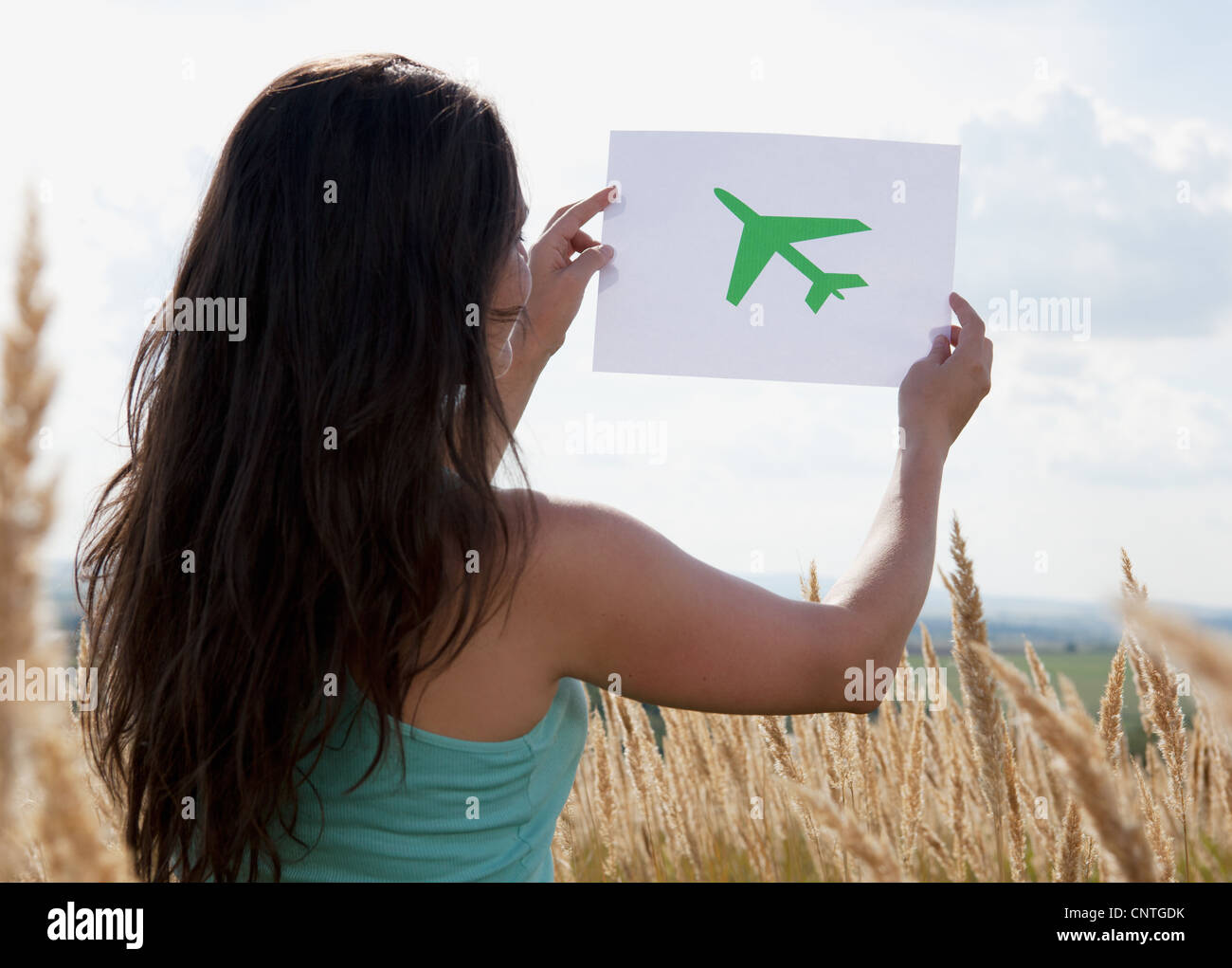 Frau mit Bild von Flugzeug im Himmel Stockfoto