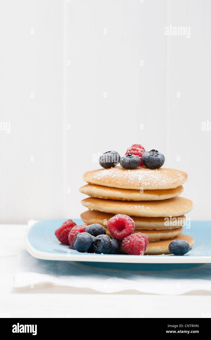 Beeren und Zucker auf Stapel von Pfannkuchen Stockfoto