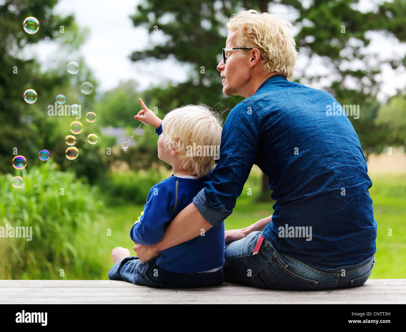 Vater und Sohn, die Bläschen im Freien zu bewundern Stockfoto