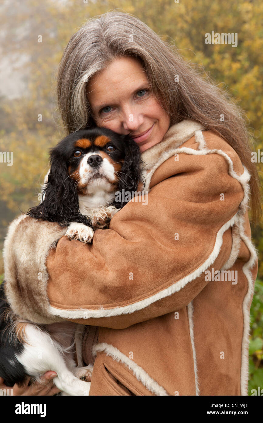 Ältere Frau umarmt Hund draußen Stockfoto
