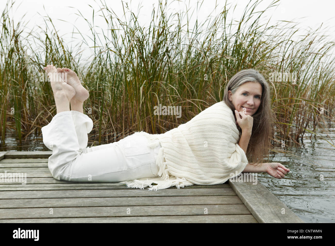 Ältere Frau entspannend auf hölzerne dock Stockfoto