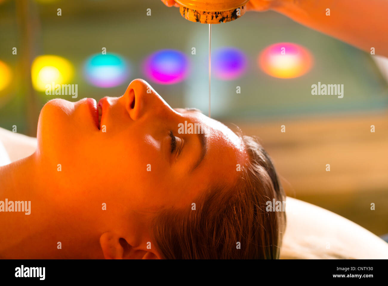 Frau genießen eine Ayurveda Öl massage-Behandlung in einem Spa mit Chromotherapie Stockfoto