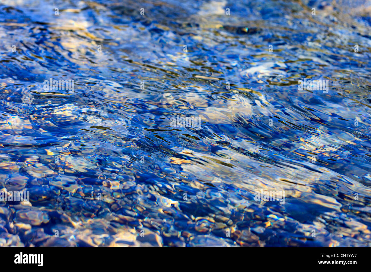 Kieselsteine unter Wasser, Wellen, Reflexion Stockfoto