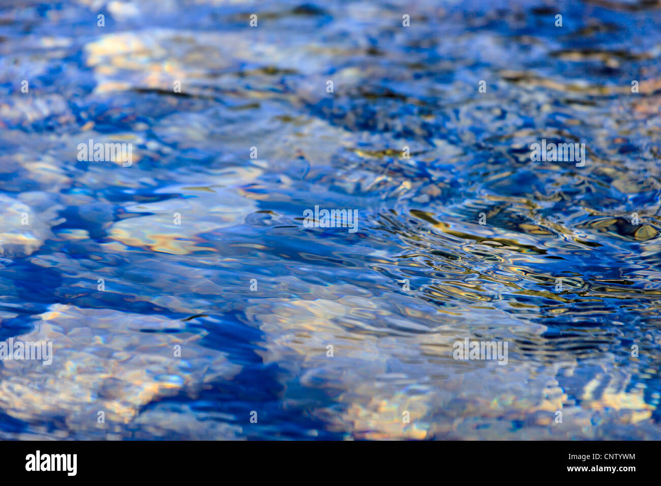 Kieselsteine unter Wasser, Wellen, Reflexion Stockfoto