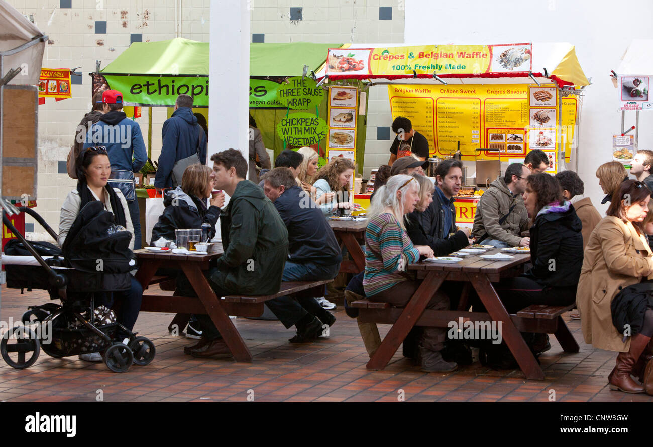 Menschen, die dem Mittagessen in der Food Hall in The Old Truman Brewery, Brick Lane, London, England, UK Stockfoto