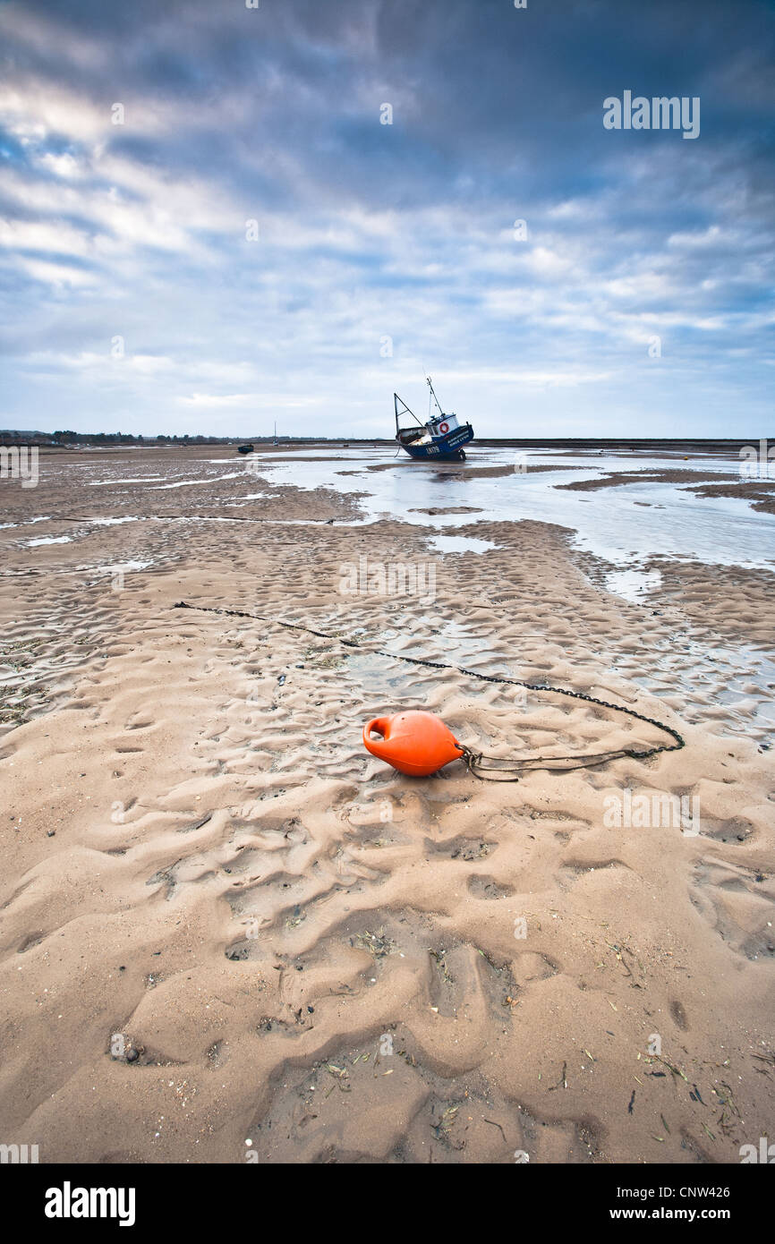 Seascape Foto eines Bootes bei Ebbe am Brancaster Staithe an Norfolk Nordküste Stockfoto