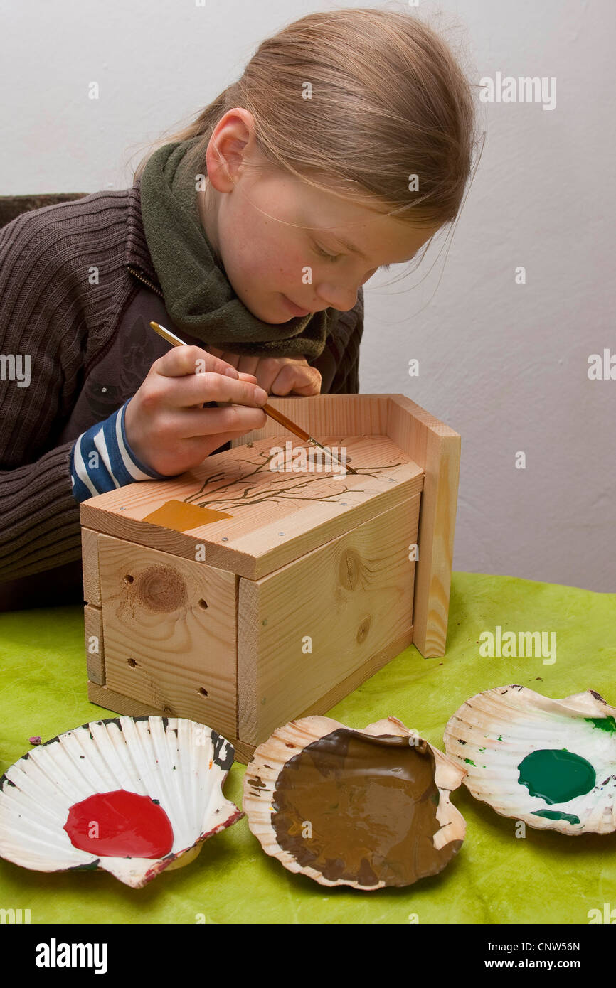 Mädchen, die Reinigung ein Vögel-Nest-Kiste Stockfoto