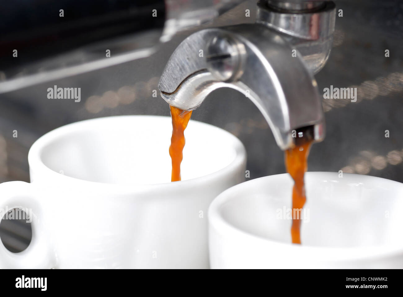 Ein Schuss von Kaffee in zwei Espresso-Tassen gießen. Fokus auf hinteren Portafilter Auslauf. Stockfoto