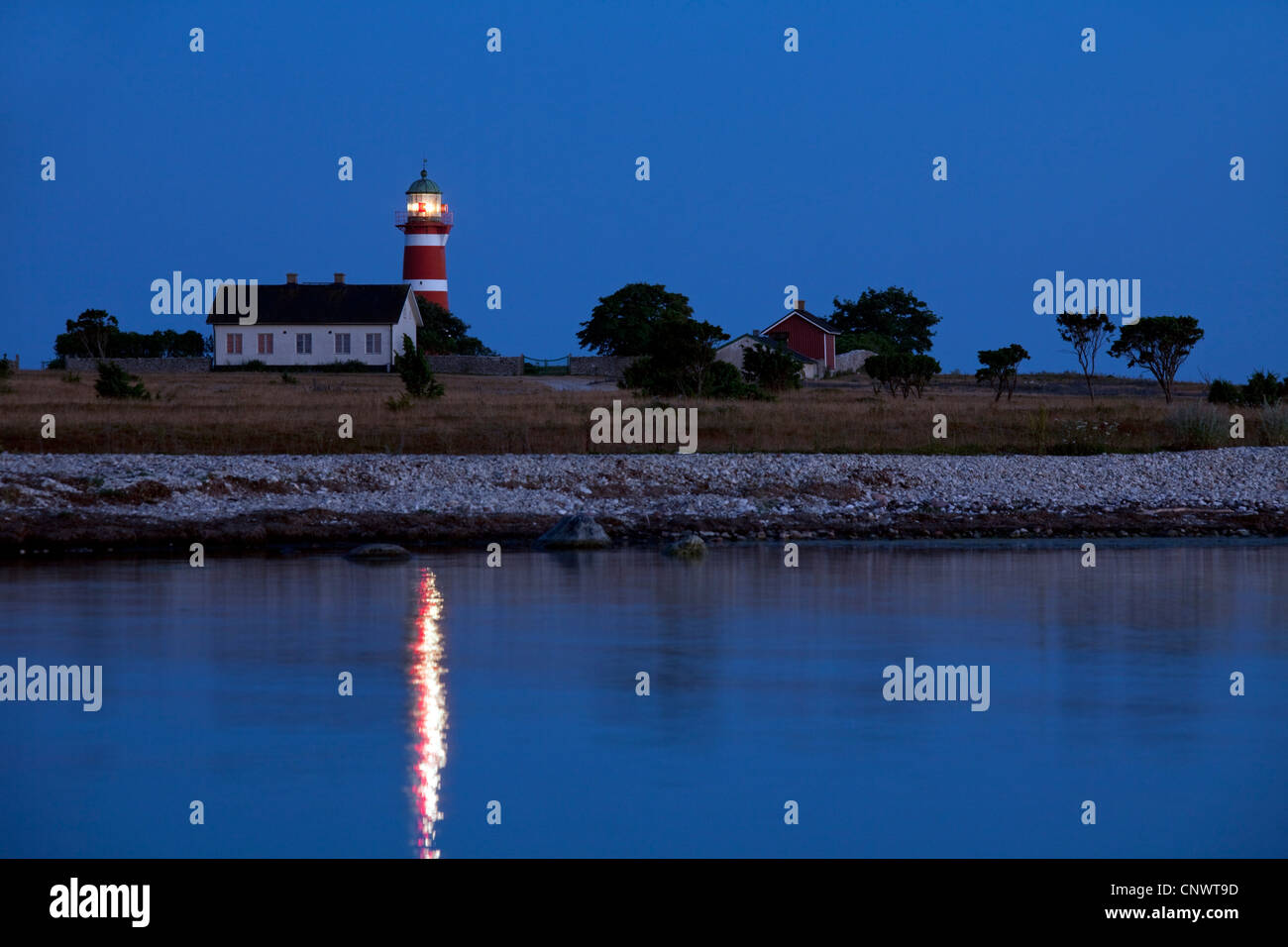 Die rot-weißen Leuchtturm Närs Fyr am Närsholmen auf der Insel Gotland, Schweden bei Sonnenuntergang Stockfoto