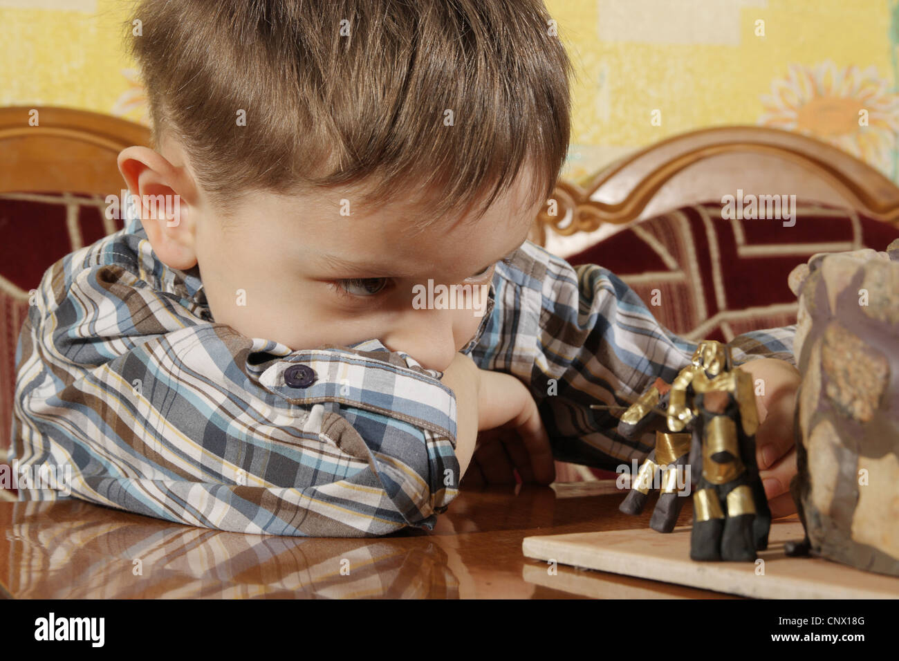 Der junge von fünf Jahren spielt mit Plastilin Ritter in Rüstung Stockfoto