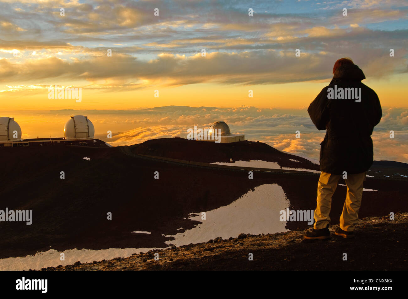 Mann beobachtet das astronomische Observatorium auf Mount Mauna Kea bei Sonnenuntergang, USA, Hawaii Stockfoto