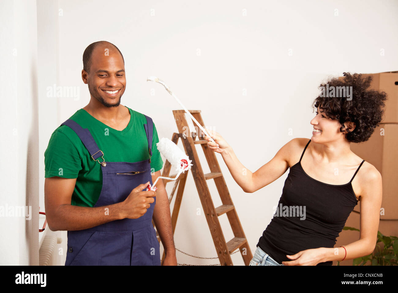Eine verspielte Paare, die Spaß beim Malerei Wohnung Stockfoto