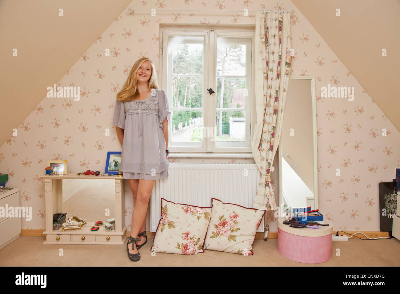 Ein junges Mädchen in ihrem Schlafzimmer lächelnd stehen Stockfoto