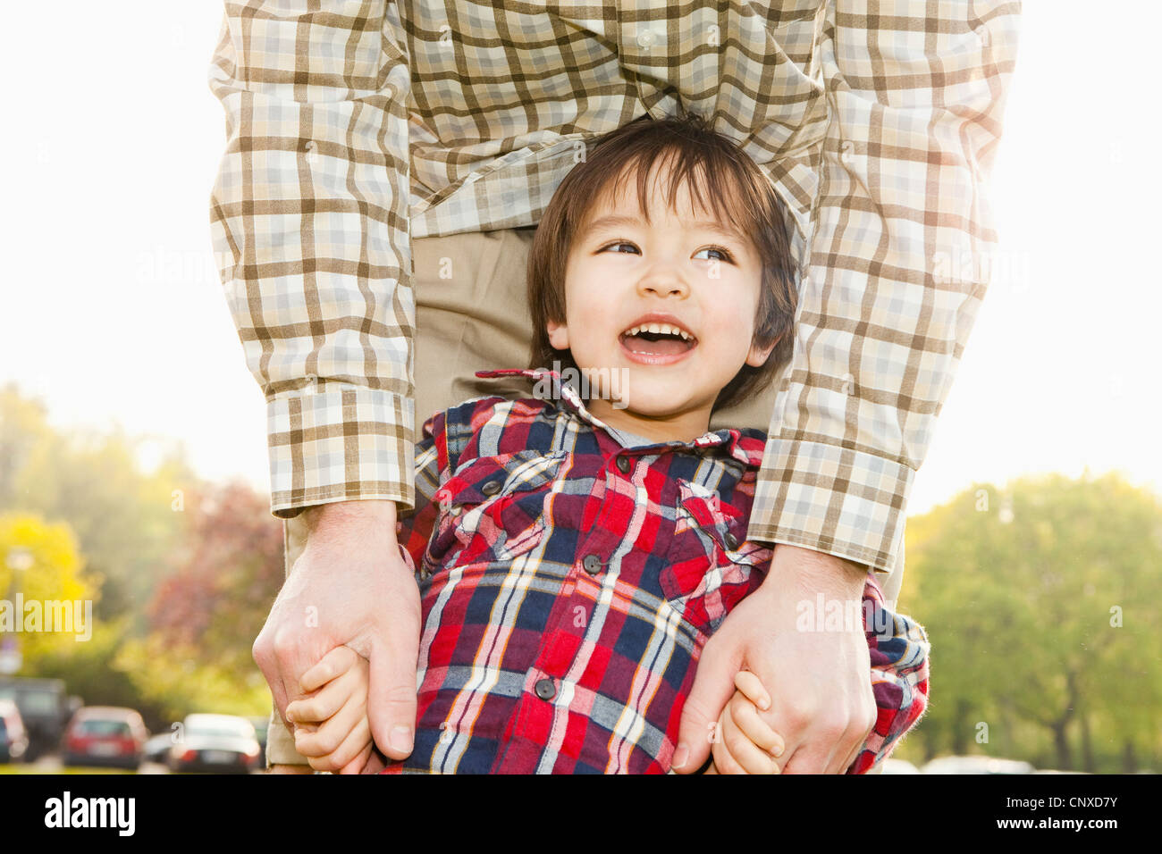 Ein Sohn Hand in Hand mit Vater und lachen, Sohn im Fokus Stockfoto