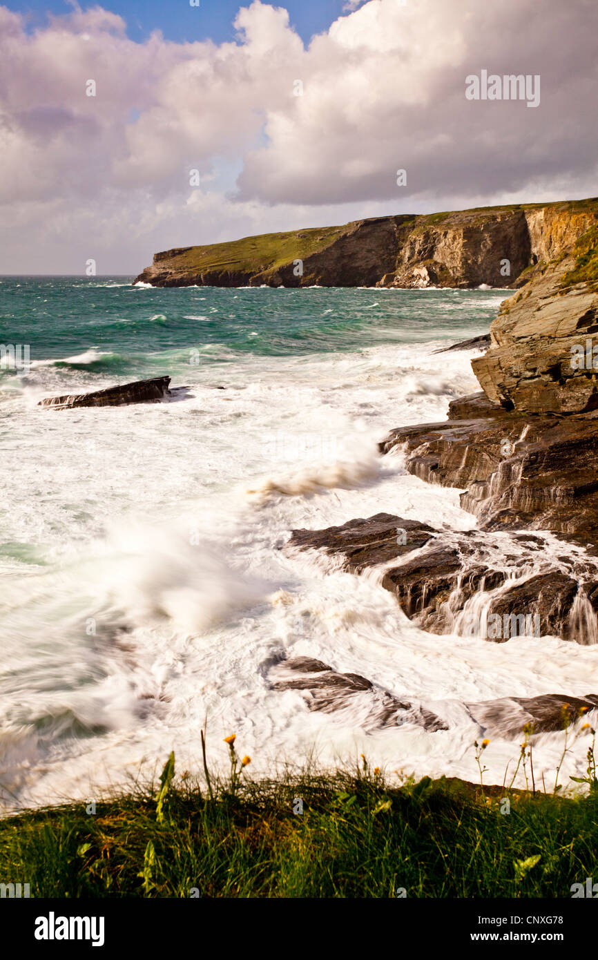 Surfen Sie über Felsen bei Flut an der kornischen Küste Trebarwith Strand brechen Stockfoto