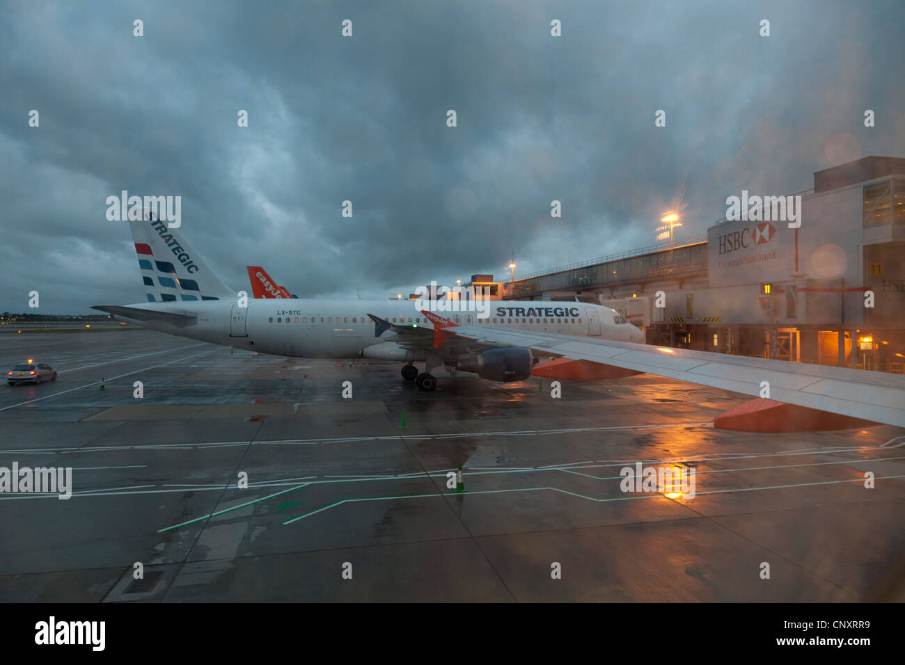 Strategische Airlines Flugzeuge stehen am Gatwick Flughafen Süd-Terminal in er am frühen Morgen an einem feuchten und stürmischen Tag Stockfoto