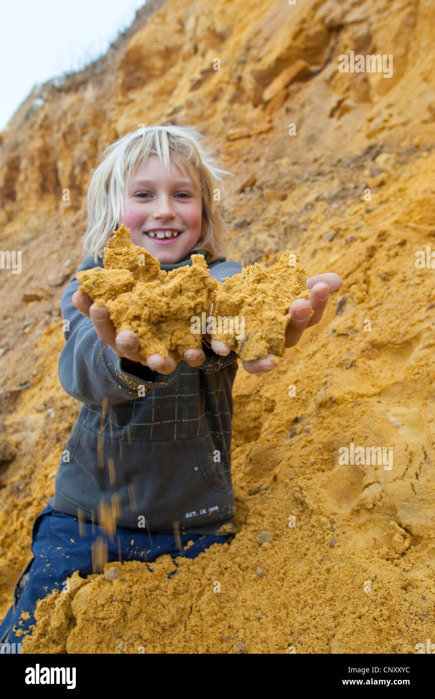 junge bunte Erde zu sammeln, um die Farbe mischen mit ihm zusammen mit Wasser "und" einfügen, Deutschland Stockfoto