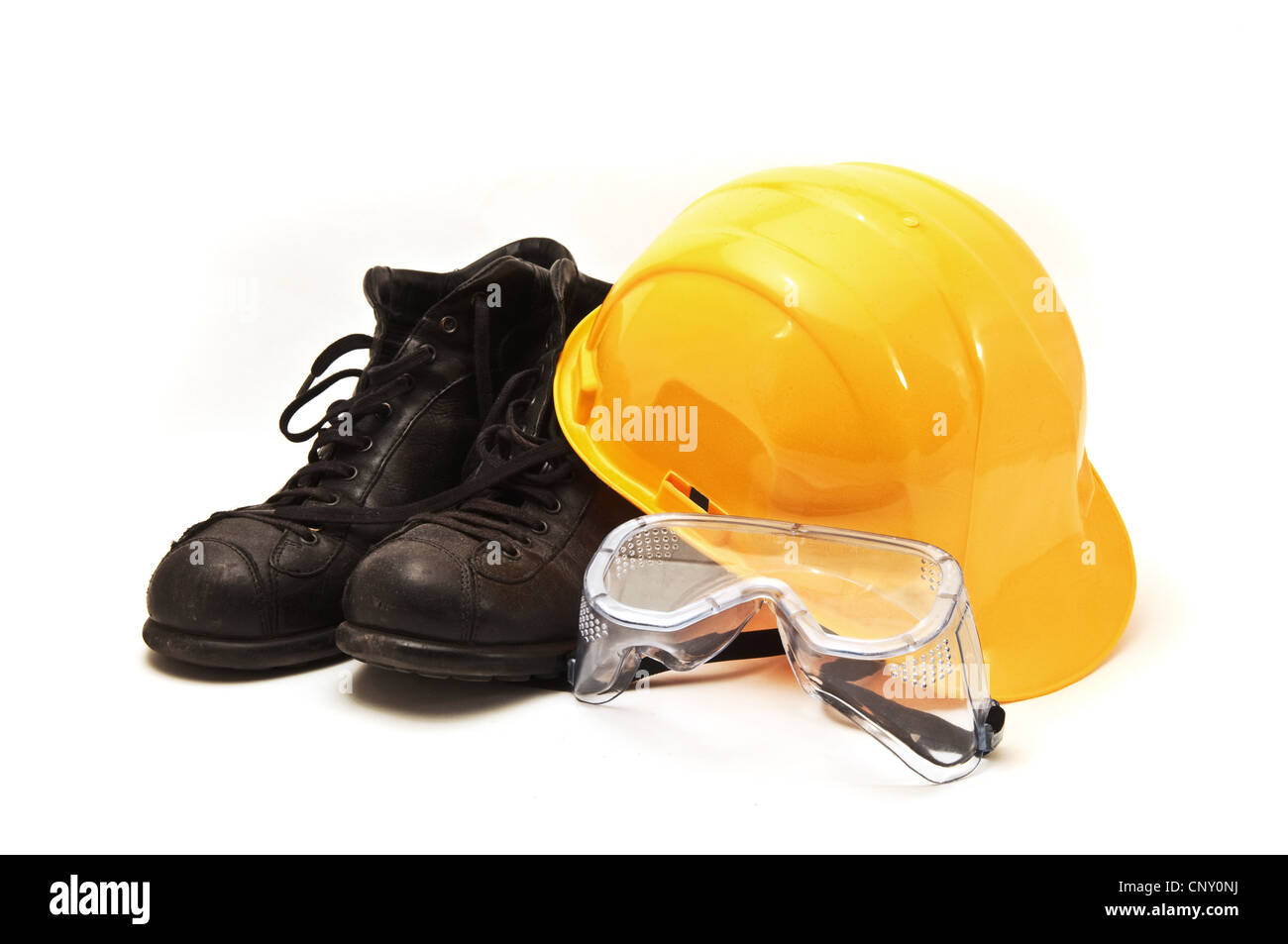 Gelb Schutzhelm, alte Lederstiefel und Schutzbrille, Schutzausrüstung in der Bauindustrie. Stockfoto