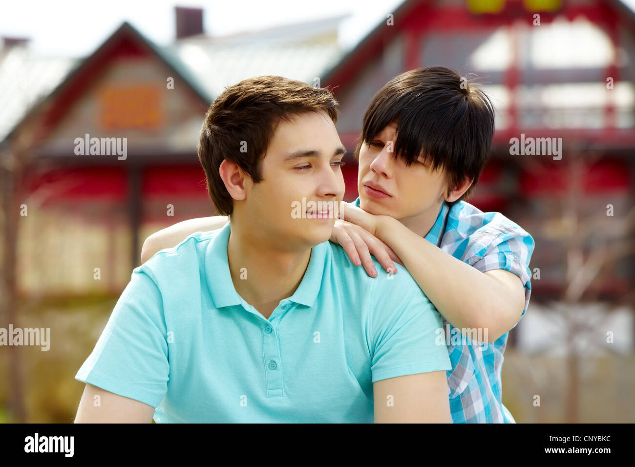 Gay Mann lächelnd, während sein Freund blickte ihn mit Stille Frage Stockfoto