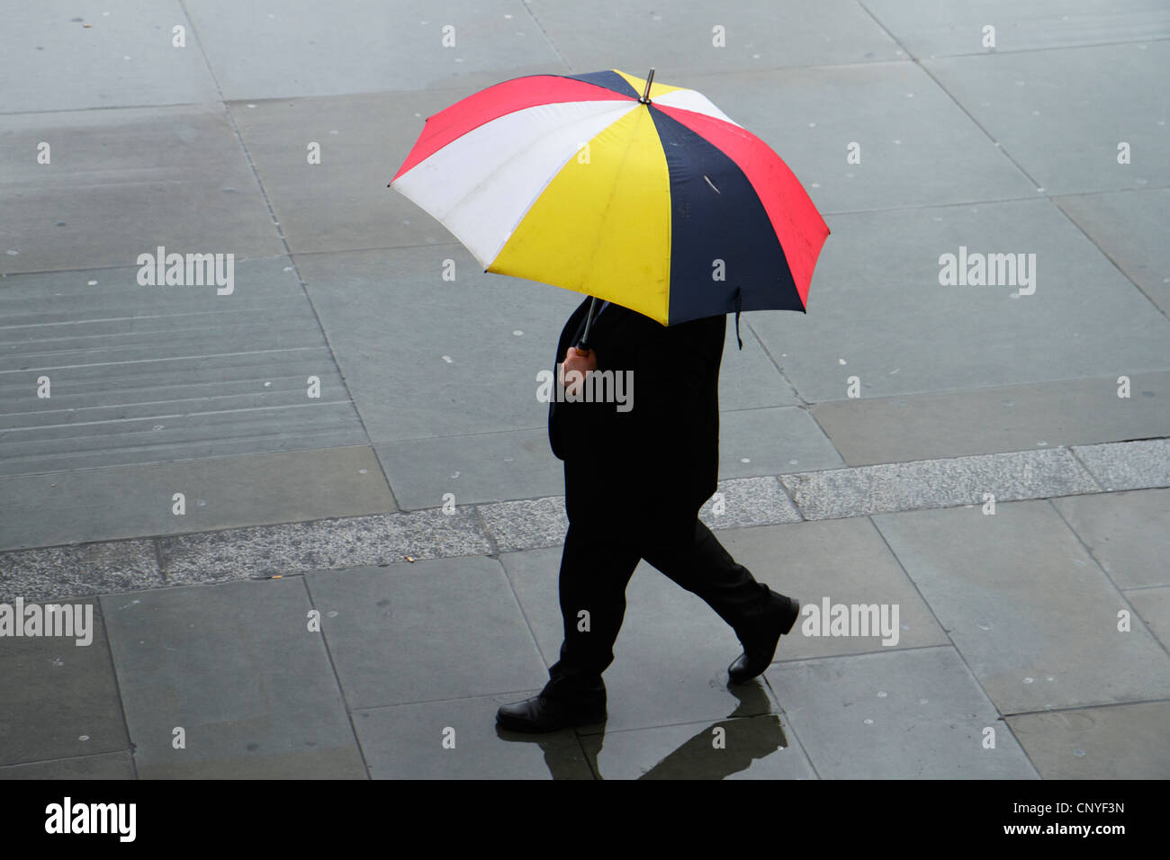 Mann im Regen mit Sonnenschirm, London UK Stockfoto