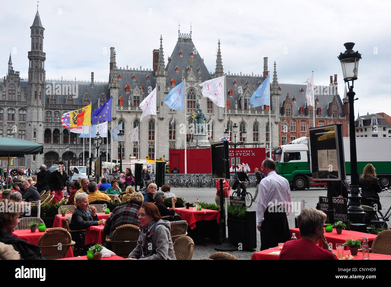 Belgien - Brügge - Marktplatz - Kulisse der alten gotischen Rathaus - National Flaggen - bunten Restaurant das Leben Stockfoto