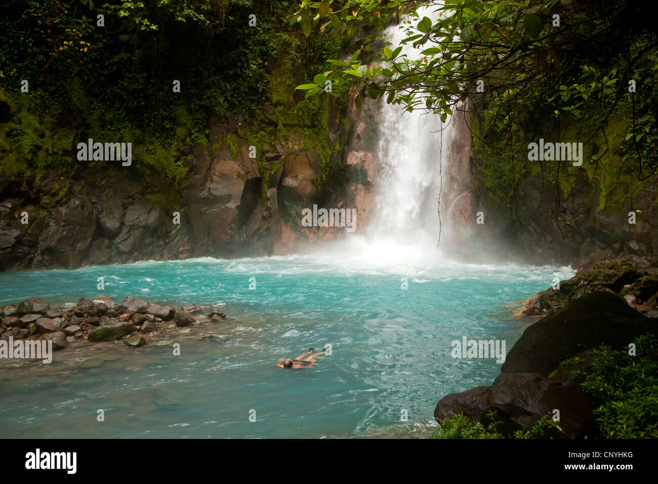 touristischen Schwimmen am Wasserfall mit den blauen Wassern des Rio Celeste im VolcanTenorio Nationalpark, Costa Rica, Stockfoto