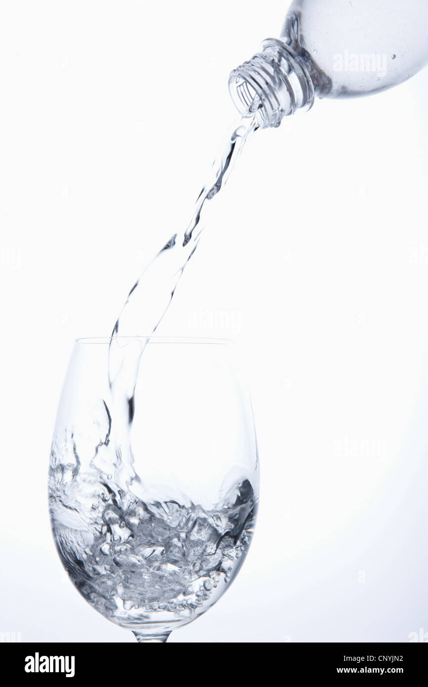 Wasser aus der Flasche in das Glas gießen Stockfoto