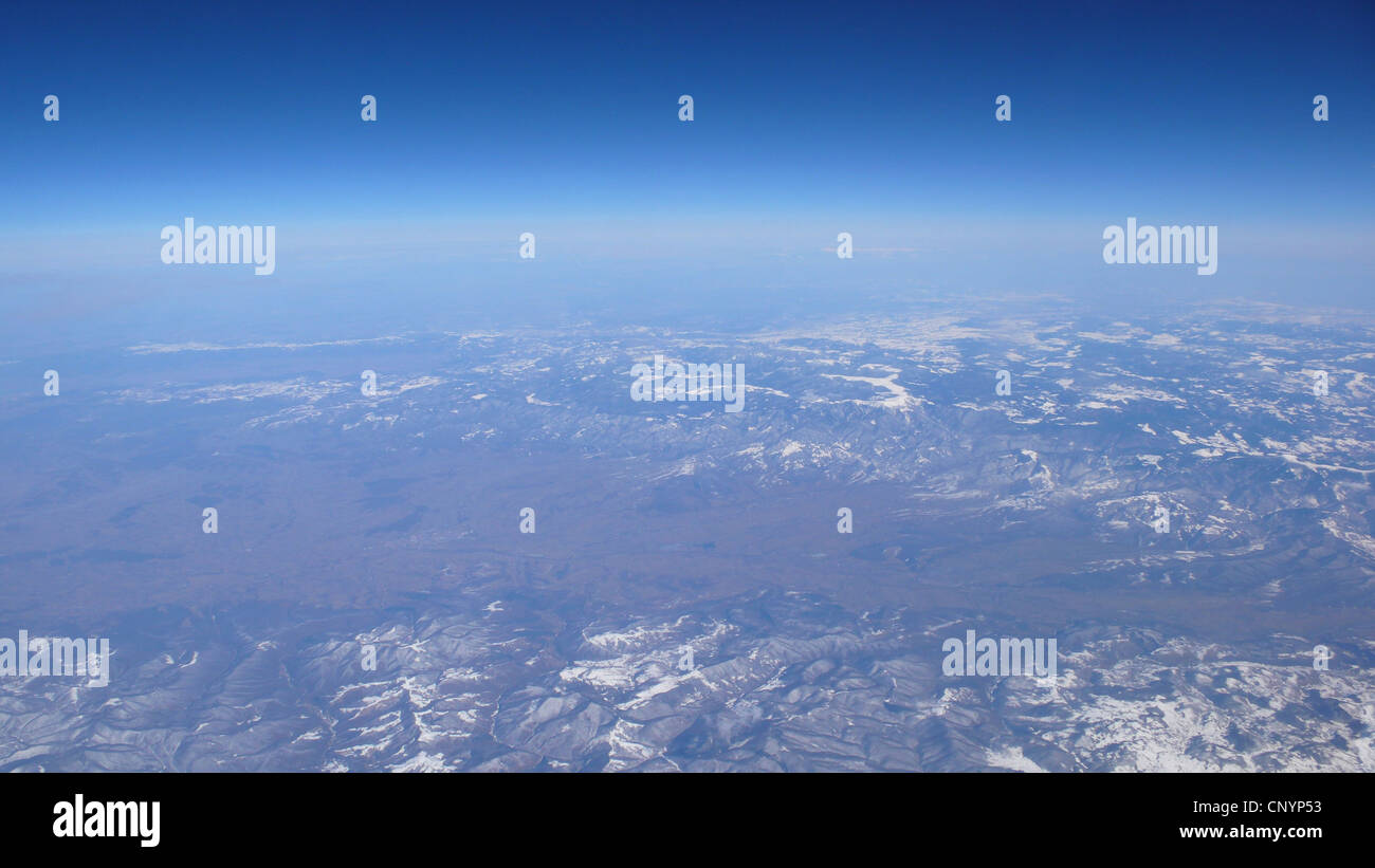 Blick über eine weite Berglandschaft aus einem Flugzeugfenster Stockfoto