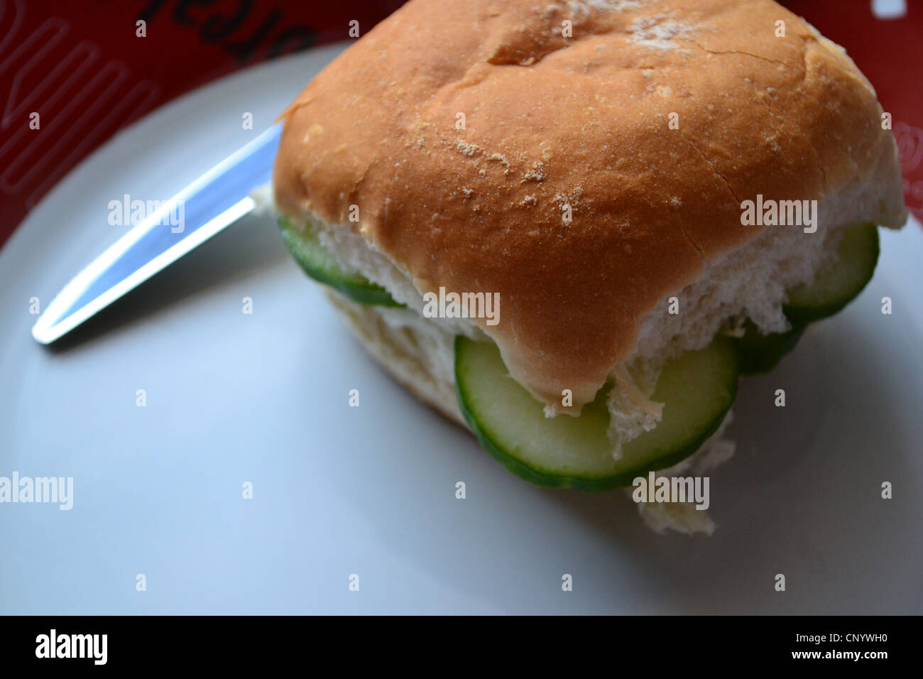 Sandwich Snack, Gurke Roll und einem Messer auf einen Teller. Stockfoto