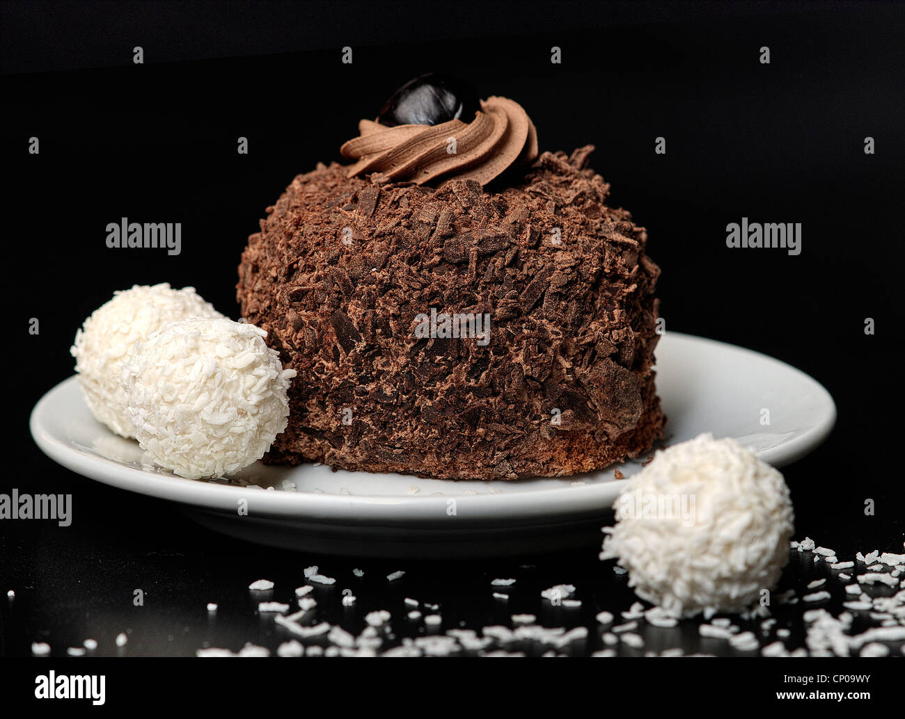 Schokoladenkuchen mit Bounty-Kugeln und Schokoladencreme Stockfoto