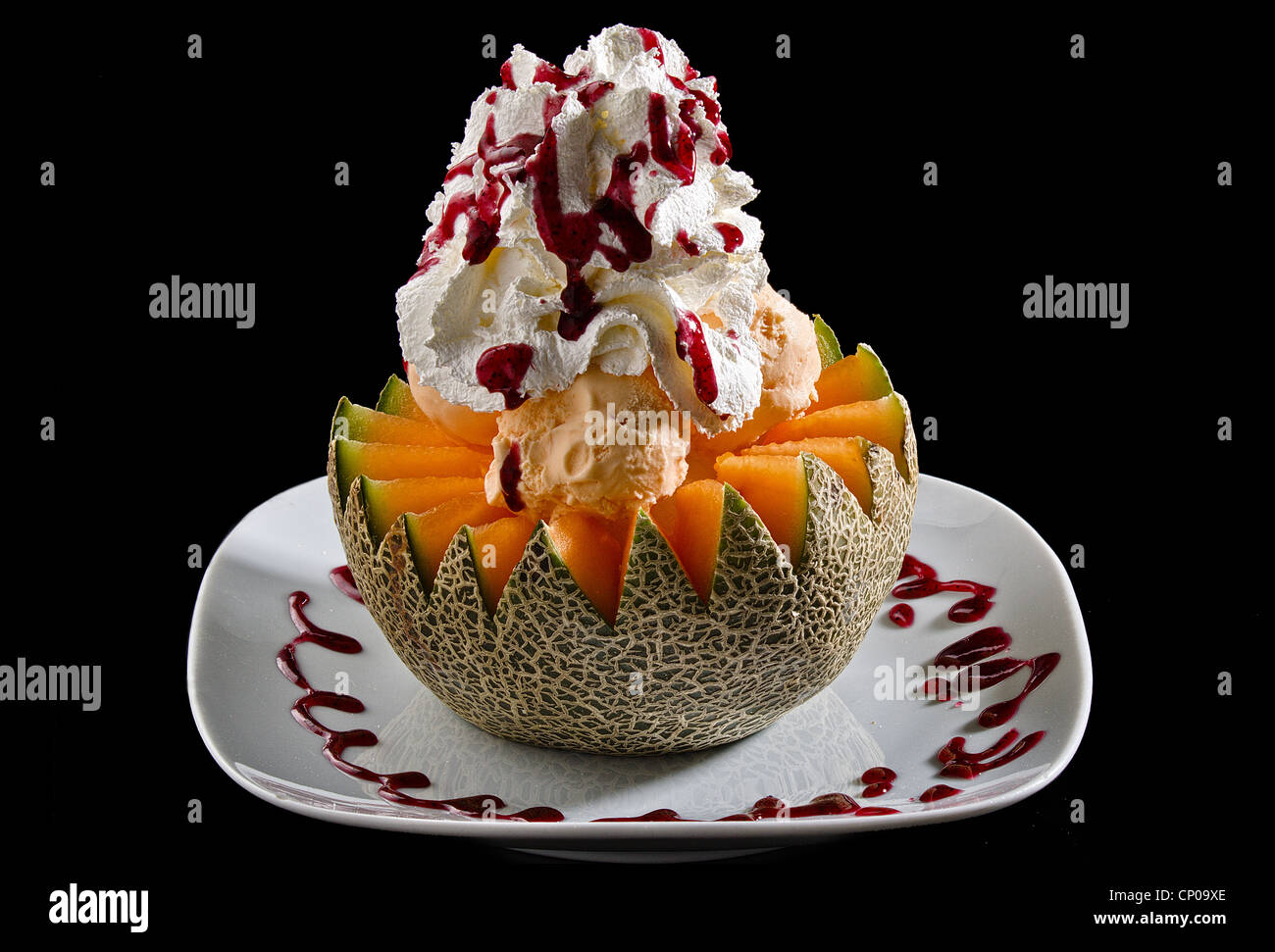 Goldene Melone mit Eis und Schlagsahne Stockfoto