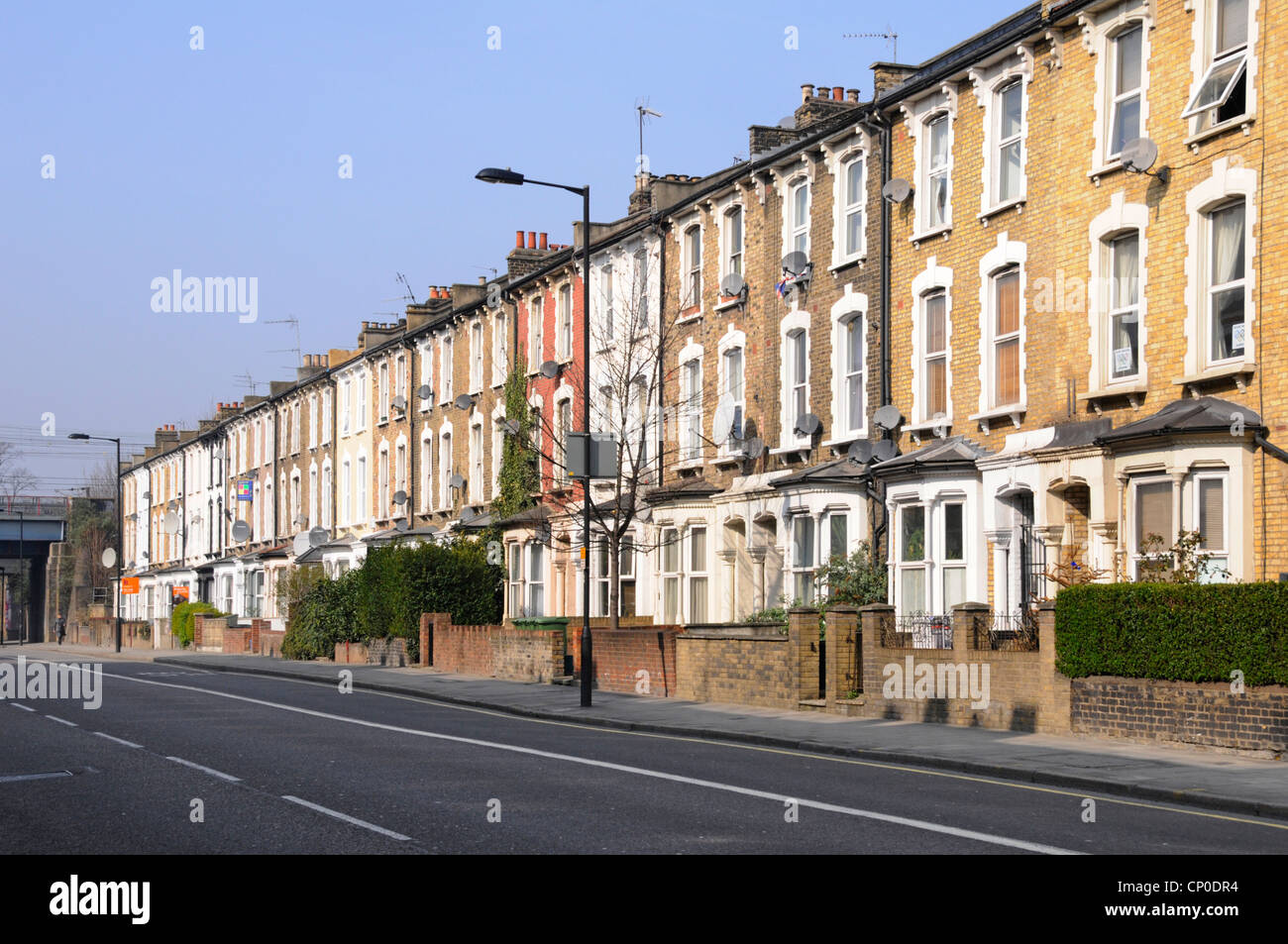 Lange Reihe von alten 3-stöckigen Wohnungen und Apartments mit Terrassen, keine geparkten Autos oder Verkehr in Hackney London nahe zum Stadtzentrum und Bahnhof England UK Stockfoto