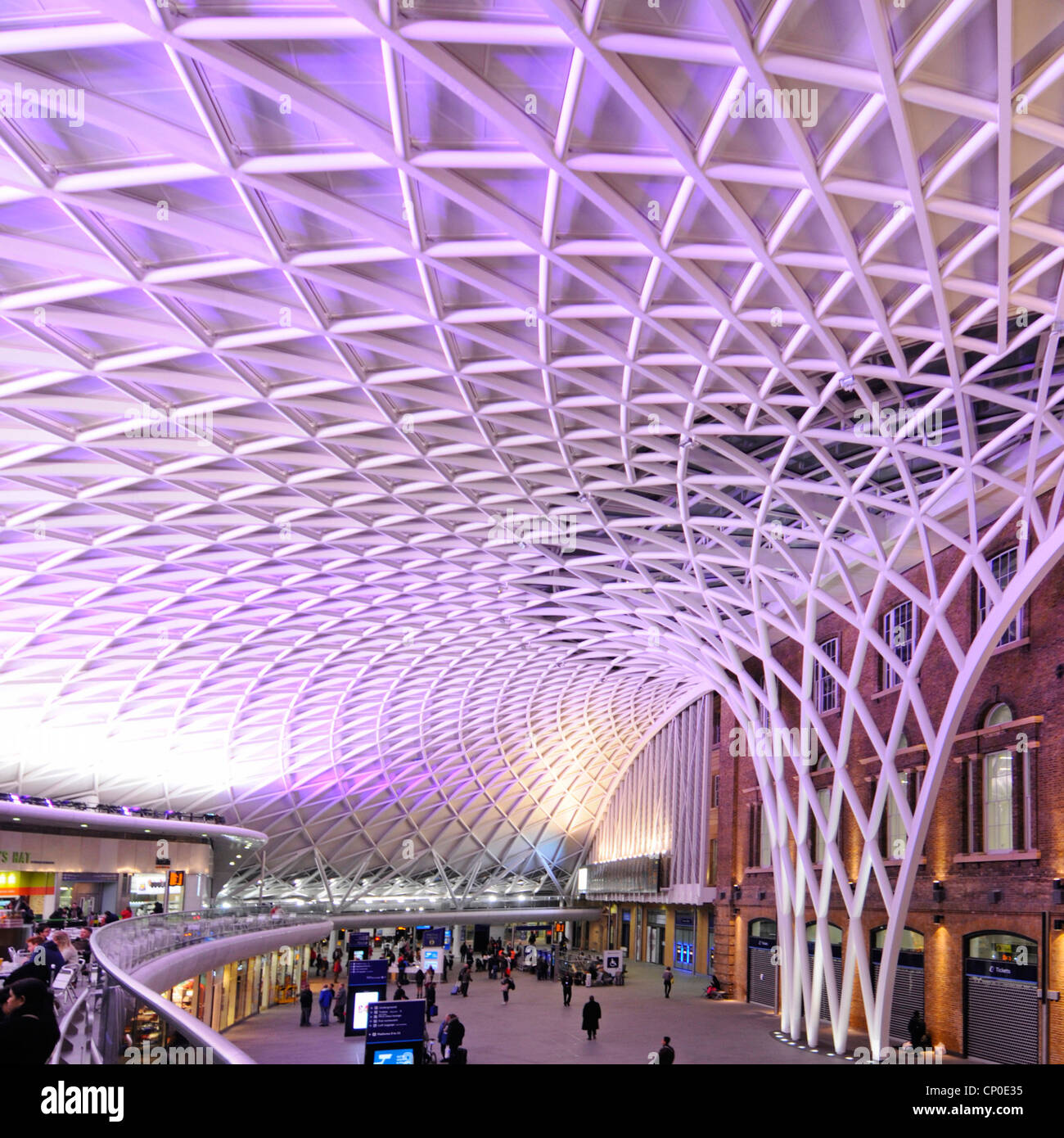 Nachts Kings Cross Bahnhof Abfahrt Konkurs mit Zwischengeschoss & gemusterter futuristisch beleuchteten Deckenstruktur London England Stockfoto