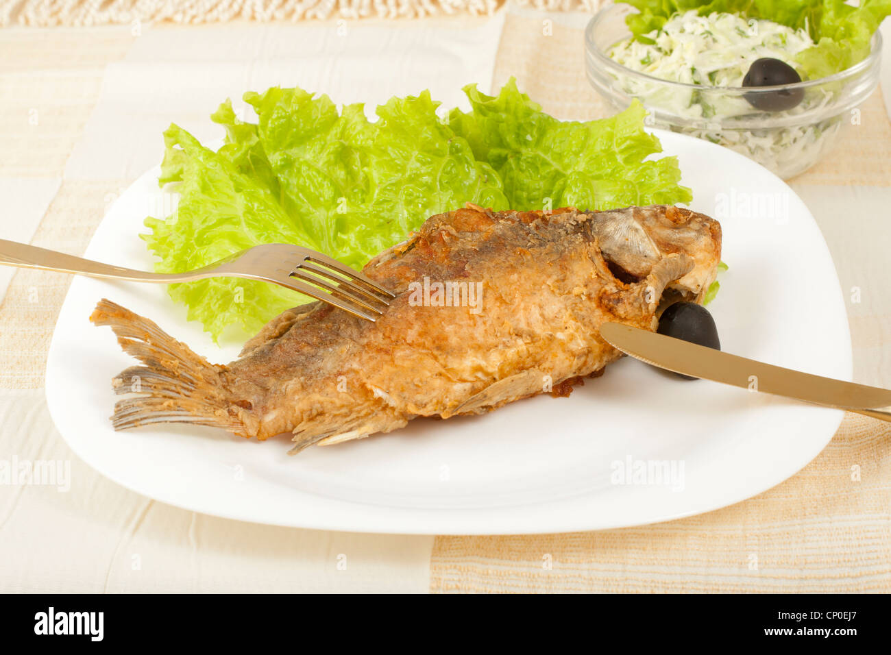 gebratener Karpfen und frühen Krautsalat auf dem Tisch Stockfoto