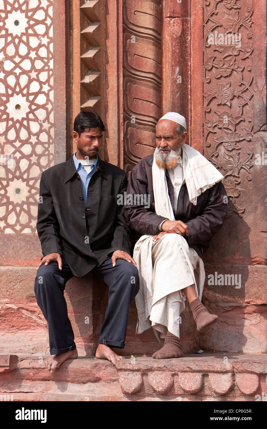 Fatehpur Sikri, Indien. Zwei Männer reden außen Eingang, Jama Masjid (Moschee Dargah).  Westliche und traditionelle Kleidung. Stockfoto