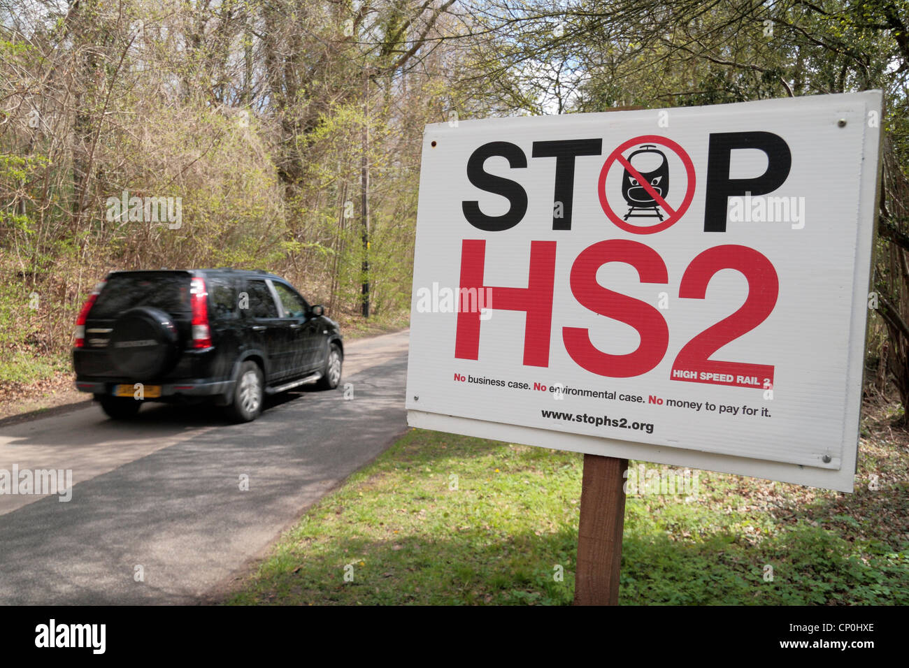 Ein Auto beschleunigt vorbei an einer "Stop HS2" Schild (Apr 2012) auf einer Straße außerhalb Wendover, Buckinghamshire, England. Stockfoto