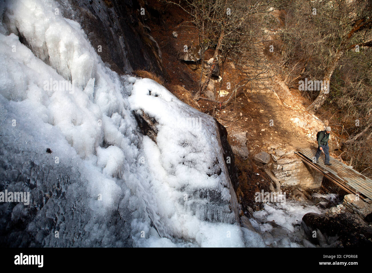 Vorbei an einem gefrorenen Wasserfall auf der Spur nach Gokyo Ri in der Everest-Region von Nepal Trekker Stockfoto