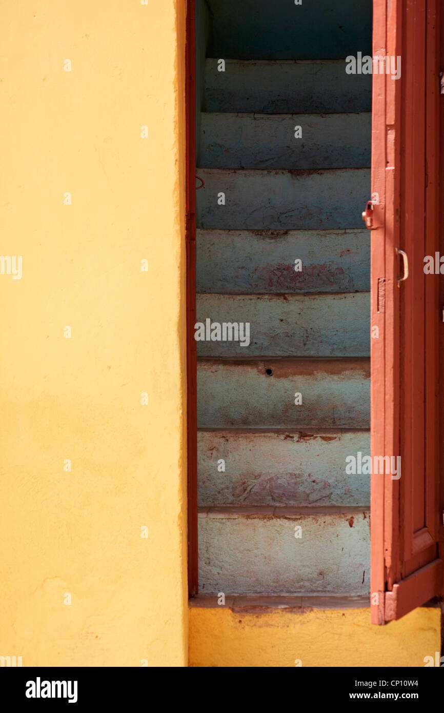 offene Tür mit Treppe hinauf in gelben Mauern umgebene Gebäude in Trinidad, Kuba, Westindische Inseln, Karibik, Mittelamerika im März Stockfoto