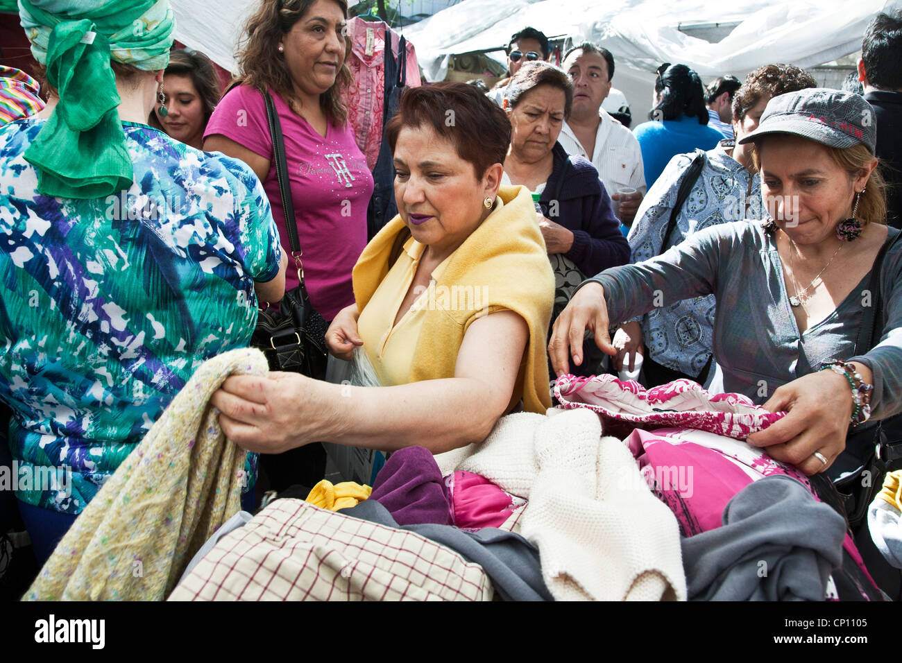 Mexikanische Mittelklasse-Frauen begierig auf ein Schnäppchen Auschecken Haufen Kleidung am Wochenende Flohmarkt im Roma-Viertel Mexiko-Stadt Stockfoto