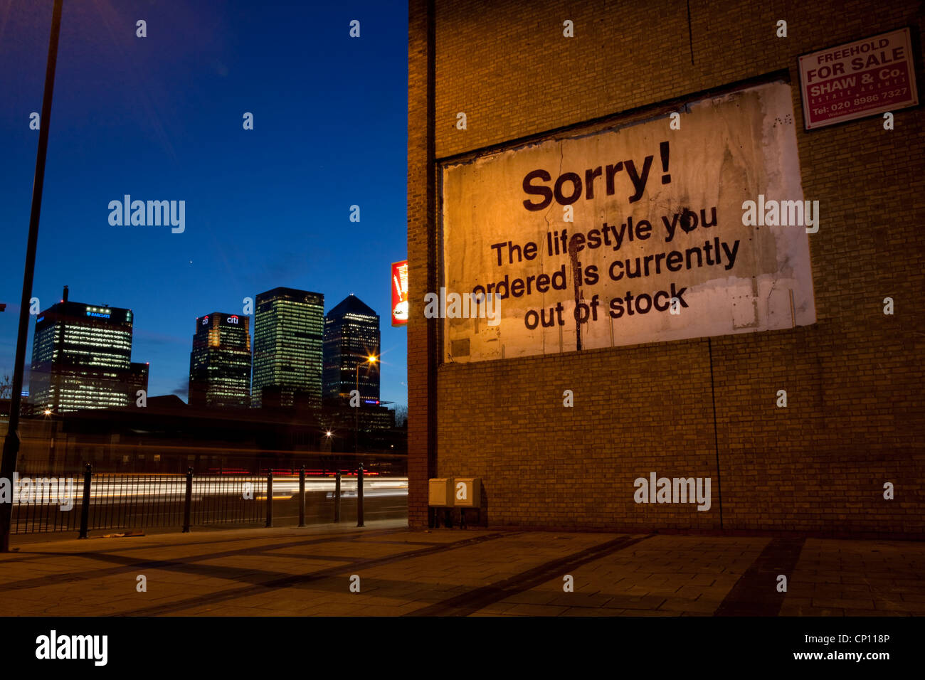 Original Banksy "tut mir leid! Die Lebensweise, die Sie bestellt ist derzeit nicht lieferbar "in East London mit Canary Wharf in der Ferne. Stockfoto