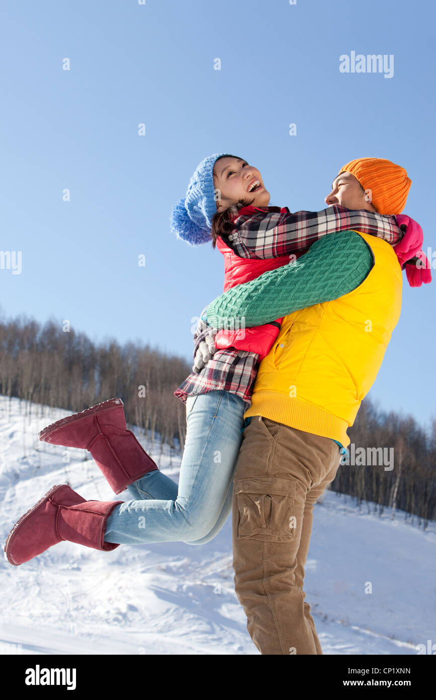 Junge Paare, die Spaß im Schnee Stockfoto