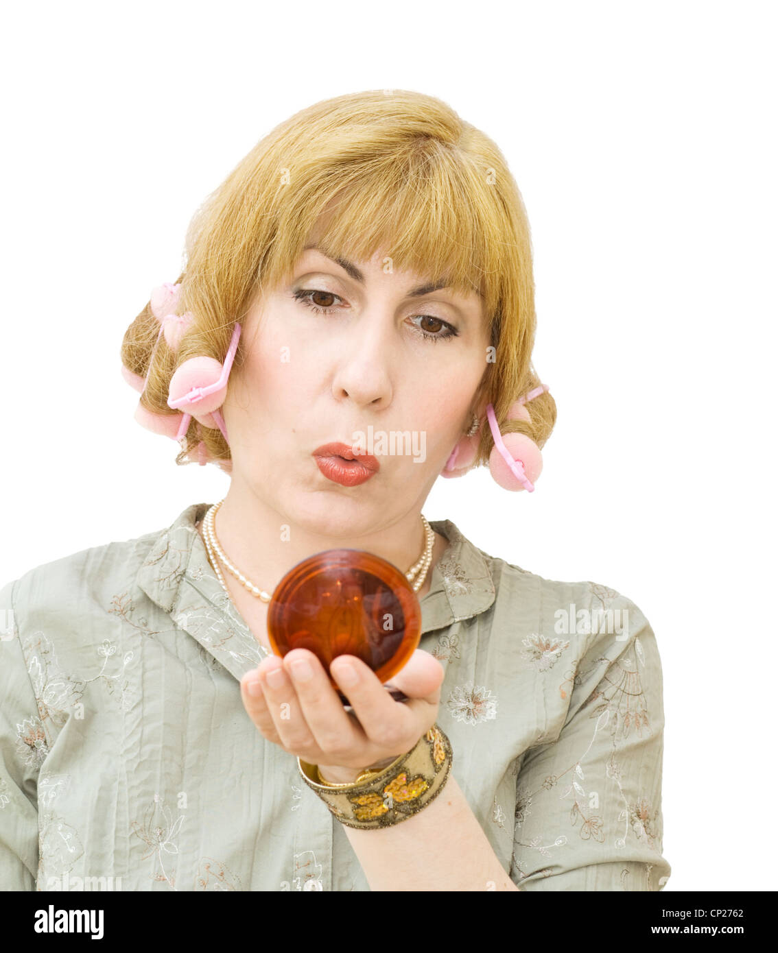 Hausfrau putting Make-ups, immer bereit zu gehen, Party, tragen Lockenwickler und Blick in den Spiegel. Über weiße Rückseite isoliert Stockfoto