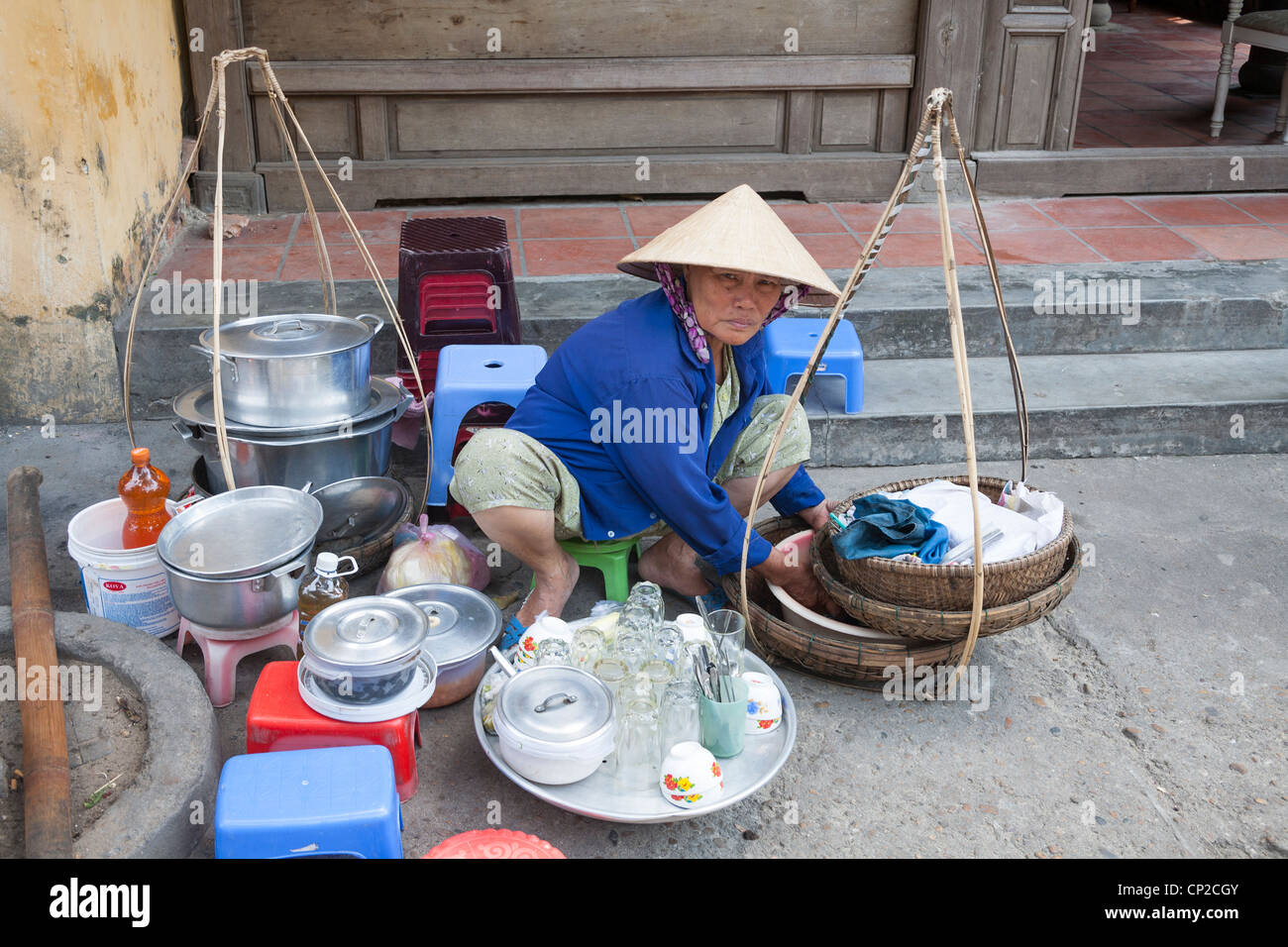 Frau verkaufen Speisen und Getränke in einer Straße in der Altstadt Hoi An, Provinz Quang Nam, Vietnam Stockfoto Frau verkaufen Speisen und Getränke in einer Straße in der Altstadt Hoi An, Provinz Quang Nam, Vietnam Stockfoto