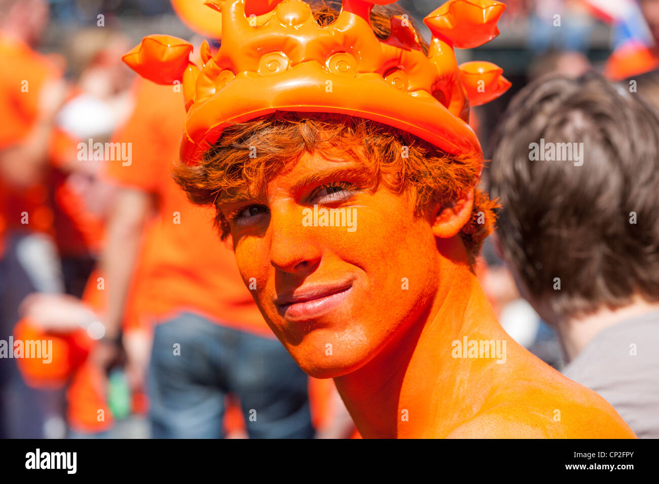Amsterdam-Porträt eines glücklichen jungen Mannes mit orange Gesicht malen Könige am Königstag. Niederlande Holland Stockfoto