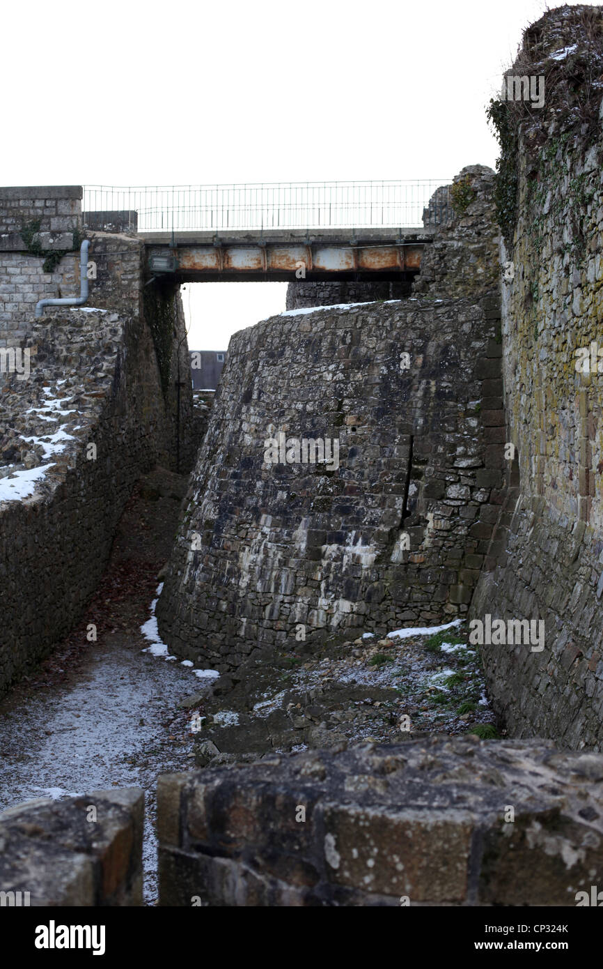 Dies ist ein Foto von einem Wassergraben von einer verlassenen Burg in Schutt und Asche. Wir Cn siehe einen Stahl oder Eisen Brücke im Hintergrund, es ist Winter Stockfoto