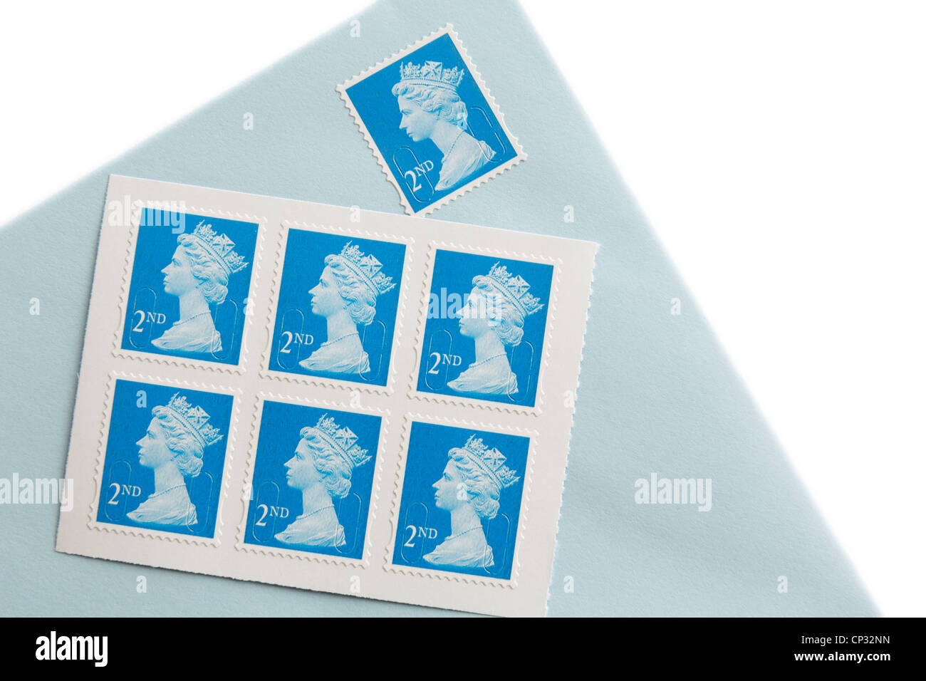 Royal Mail zweiter Klasse Briefmarken und einen Umschlag mit einem Stempel isoliert auf einem weißen. England, UK, Großbritannien. Stockfoto