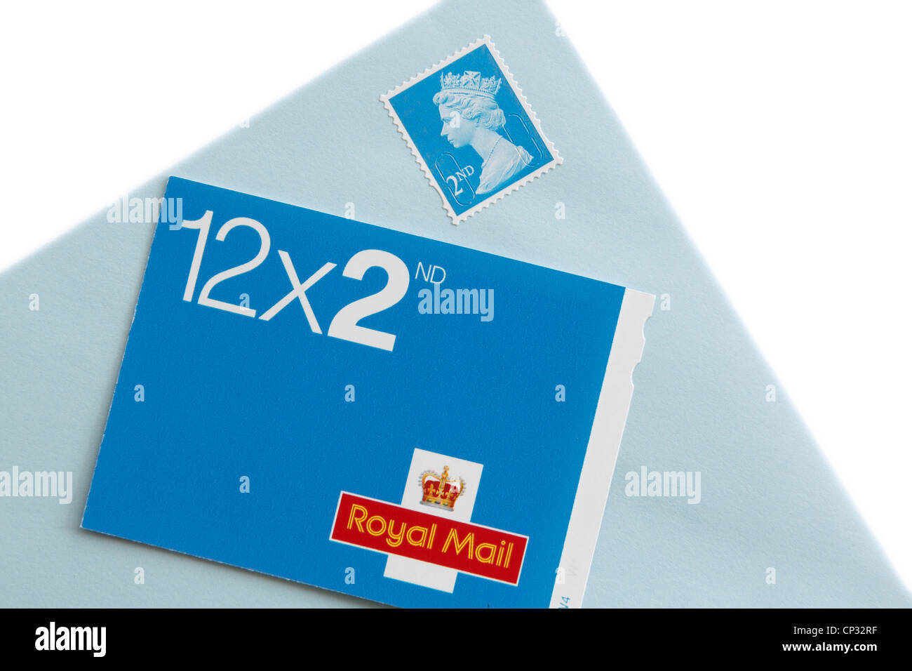 Buch der zwölf Royal Mail zweiter Klasse Briefmarken und einen Umschlag mit einem Stempel auf einem weißen Hintergrund isoliert. UK, Großbritannien. Stockfoto