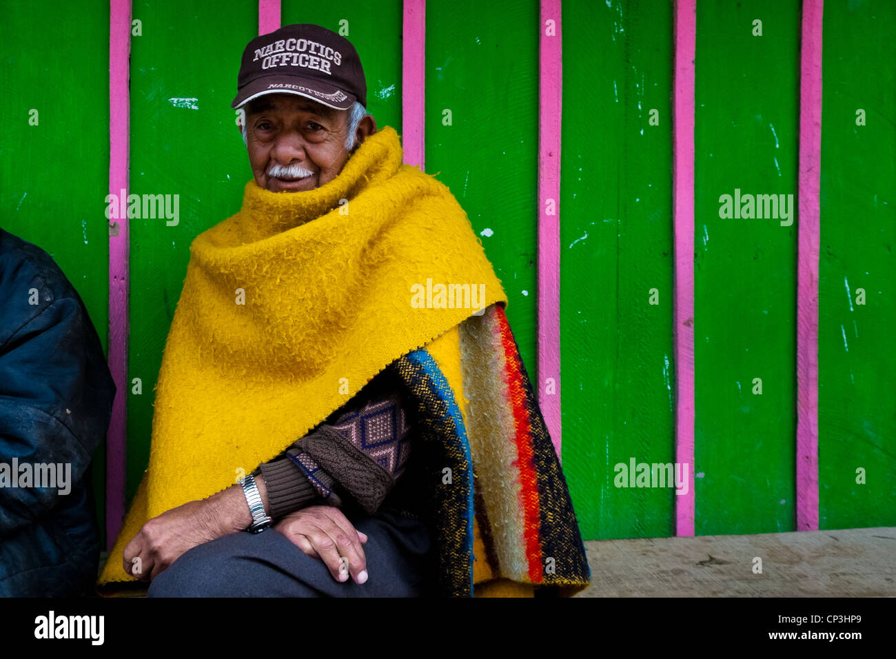 Ein kolumbianischer Mann sitzt vor seinem Haus in den Slums von Ciudad Bolívar, Bogota, Kolumbien. Stockfoto