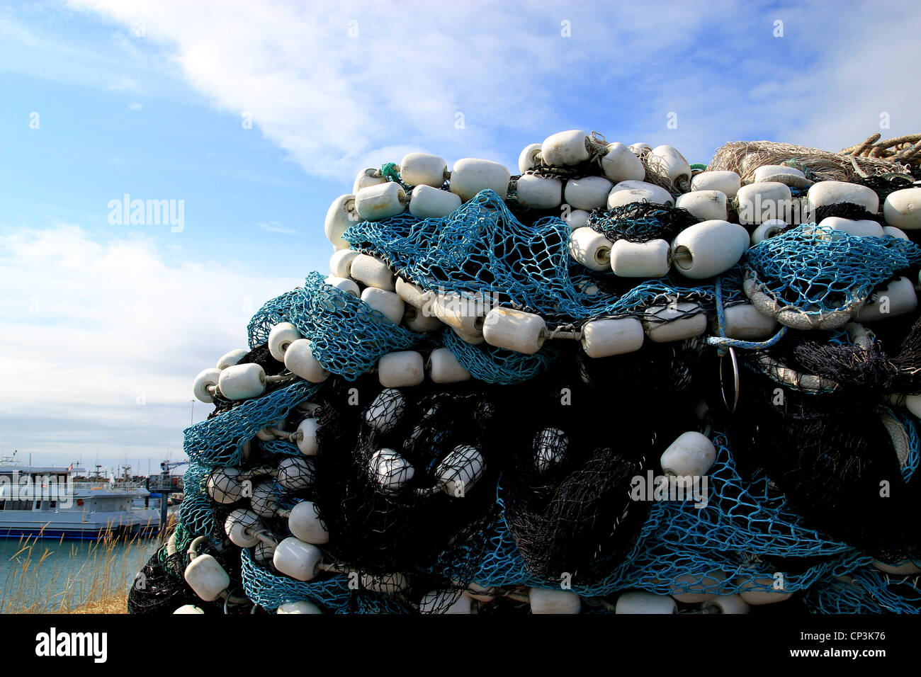 Große Haufen von bunten Fischernetze mit Schwimmern am Hafen in Vorbereitung für kommerzielle Fangsaison. Stockfoto