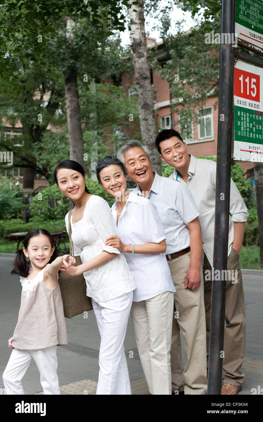 Chinesische Familie an Bushaltestelle Stockfoto